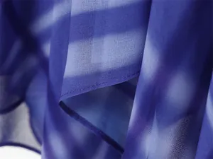 Close-up detail of blue and white printed chiffon fabric showing fine texture and hem stitching