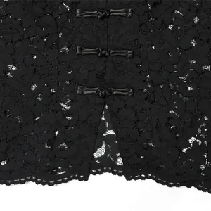 Nahaufnahme des eleganten schwarzen Spitzen-Tops mit traditionellen Knebelknöpfen und Schlitz