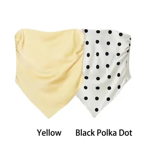 Detail view of stylish yellow and black polka dot bandeau tops with sexy side ruching.