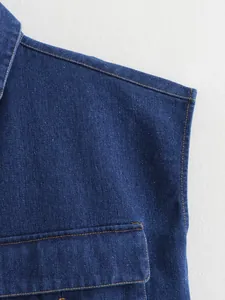 Macro close-up detail of denim vest shoulder and chest pocket with contrast stitching