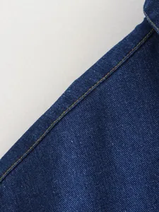High quality close-up detail showing the contrast gold stitching on a dark blue denim vest
