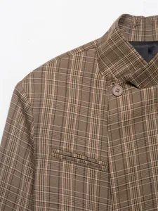 Close-up detail of women's brown plaid blazer featuring high collar and welt pocket