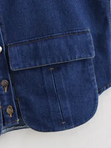 Macro detail of dark blue denim vest with contrast stitching and heart buttons