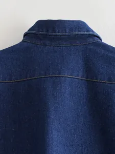 Macro close-up of blue denim vest back collar with yellow contrast stitching detail
