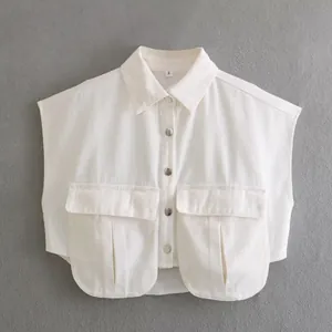 Close-up of white cropped denim vest with utility pockets and metal buttons