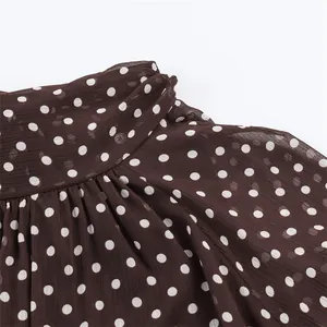 Close-up detail of a brown long sleeve polka dot shirt showing collar and texture