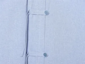 Detail der Froschverschlüsse an einem hellblauen Reinleinenhemd mit Knopfleiste.