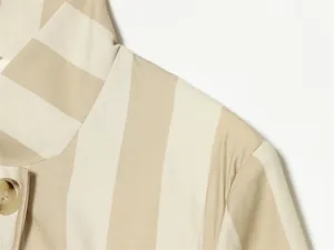 Gros plan sur la texture du tissu d'un blazer à rayures beiges et blanches avec col