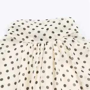 Macro view showing the fine fabric texture and polka dot pattern of the shirt collar.