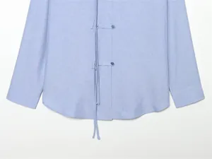 Detailaufnahme eines hellblauen Leinenhemdes mit traditionellen chinesischen Knotenschlüssen