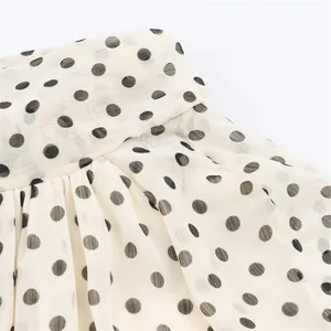 Close-up detail of the polka dot print fabric on this stylish women's chiffon blouse.