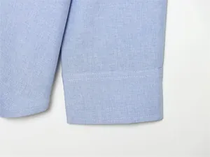 Gros plan sur le poignet d'une chemise en lin bleu clair avec des coutures propres