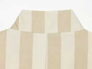 Gros plan détaillé du col officier et du tissu à rayures beiges d'un blazer d'été.