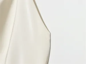 Detalle macro de la textura de seda blanca lisa y el borde de la costura terminado