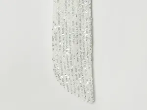 Detalle de lentejuelas blancas brillantes en un elegante vestido de noche.