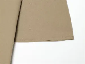 Detailed view of the clean hem stitching on a khaki asymmetric skirt fabric