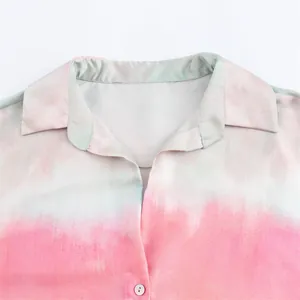 Close-up of pink tie-dye gradient print on a silk-like satin shirt collar detail