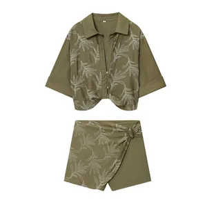 Detailed view of women's olive green two-piece set with white leaf embroidery design