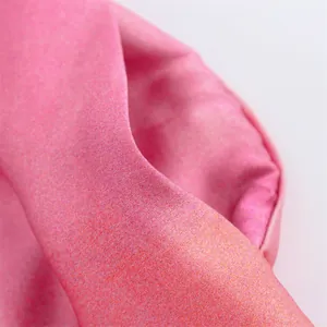 Macro detail view showing the soft pink tie-dye print fabric with luxury satin texture