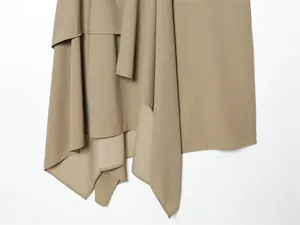 Detailed view of the elegant asymmetric draped hem on a khaki midi skirt garment
