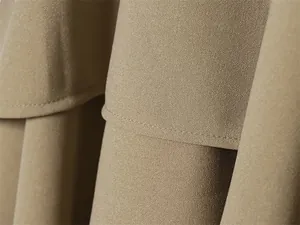 Macro detail of high-quality stitching and fabric texture on a khaki brown skirt suit