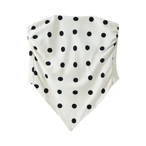 Detail view of a white polka dot strapless tube top featuring a handkerchief pointed hem