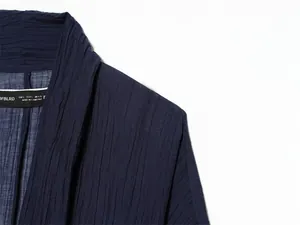 Detail shot of navy sheer textured summer jacket showing fabric and collar tag.