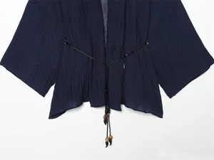 Close-up detail of navy blue crinkle effect semi-transparent summer jacket with beaded ties.