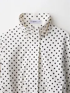 Macro view of casual white seersucker jacket with black polka dots and stand collar detail