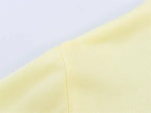 Primo piano del tessuto a maglia giallo di alta qualità e cucitura pulita sulla polo