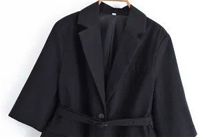 Detail of a black linen blazer featuring half-sleeves and a matching waist belt.