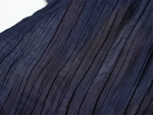 Macro view showing the semi-transparent pleated texture of the navy blue summer fabric
