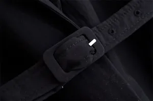 Close-up detail of the fabric-covered buckle and adjustable belt on the black linen blazer.