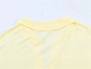 Primo piano del colletto di una polo gialla chiara con scollo a V