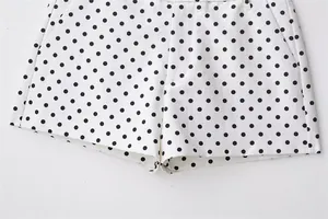 Close-up of white seersucker shorts with black polka dots featuring side pockets
