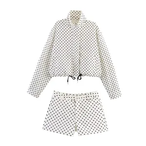 Stylish white and black polka dot jacket and shorts two-piece set for women.