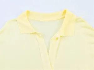 Dettaglio di una polo gialla chiara con scollo a V e colletto a costine