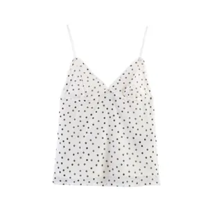 Detail showing the white silk mesh camisole with classic black polka dot pattern.