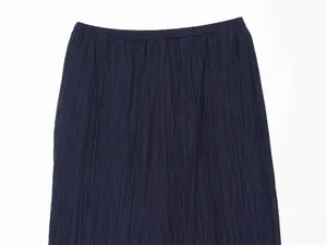 Close-up detail of dark blue summer trousers featuring vertical wrinkled fabric texture