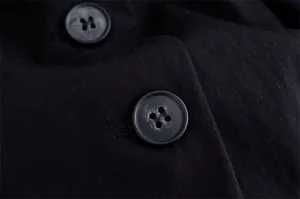 Detailed close-up showing black buttons and linen fabric texture on blazer suit