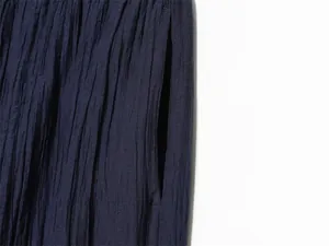 Close-up detail of navy crinkle effect fabric showing the pocket of casual pants.