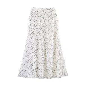 High-quality mesh fabric detail showing the classic black polka dot pattern on a midi skirt.