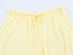 Dettaglio che mostra la vita elastica con coulisse dei pantaloni in maglia gialla