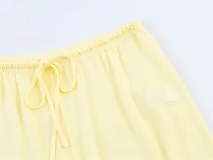 Primo piano dell'elastico in vita e della coulisse di questi pantaloni gialli chiari.