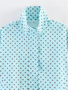 Detail shot of light blue stand collar jacket featuring dark brown polka dot pattern