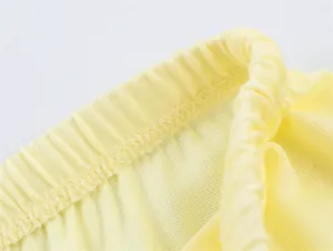 Dettaglio ravvicinato dell'elastico giallo in vita con cuciture professionali di qualità