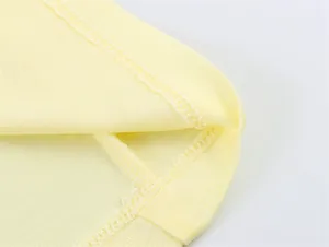 Dettaglio ravvicinato delle cuciture su polo giallo chiaro in tessuto strutturato.