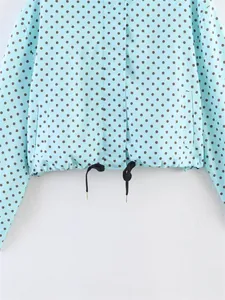 Close-up of light blue polka dot jacket hem with black adjustable drawstrings.