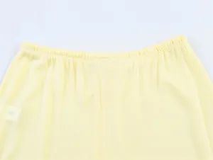 Primo piano dell'elastico in vita dei pantaloni in maglia gialla con trama morbida