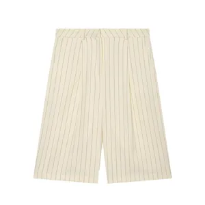 Detailed view of cream pinstriped linen shorts featuring pleats and belt loops.